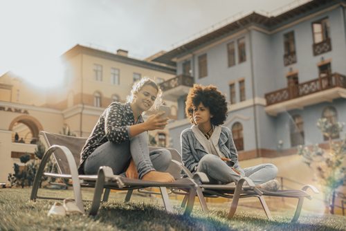 Two girls on the street recliners with the smartphone
