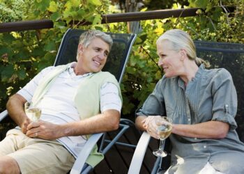Couple sitting on garden chairs with wine
