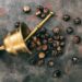 Guarana nuts and a bronze mortar on metal rusty background top view