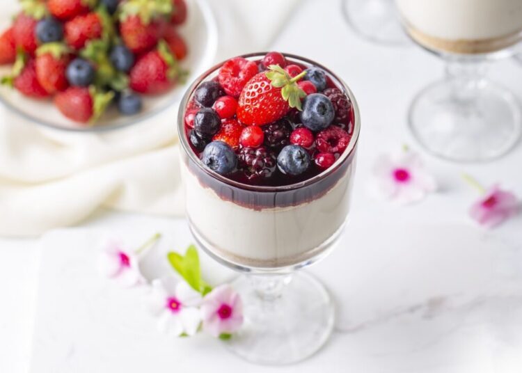 Milky sweet delicious pudding topped with forest fruits and fru