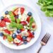 Summer fruit and berry salad with cottage cheese and mint leaves